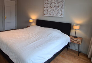 Simple bedroom with dark grey boxspring bed