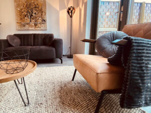 Cosy sitting area with brown sofa and light leather arm chair